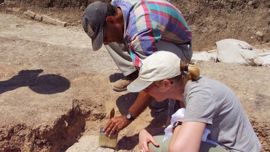 Timothy Harrison and an archaeological team member dust off a find at Tell Tayinat.