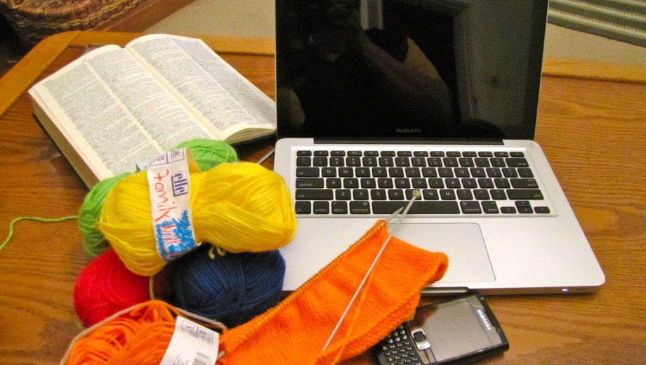 Computer with knitting and book