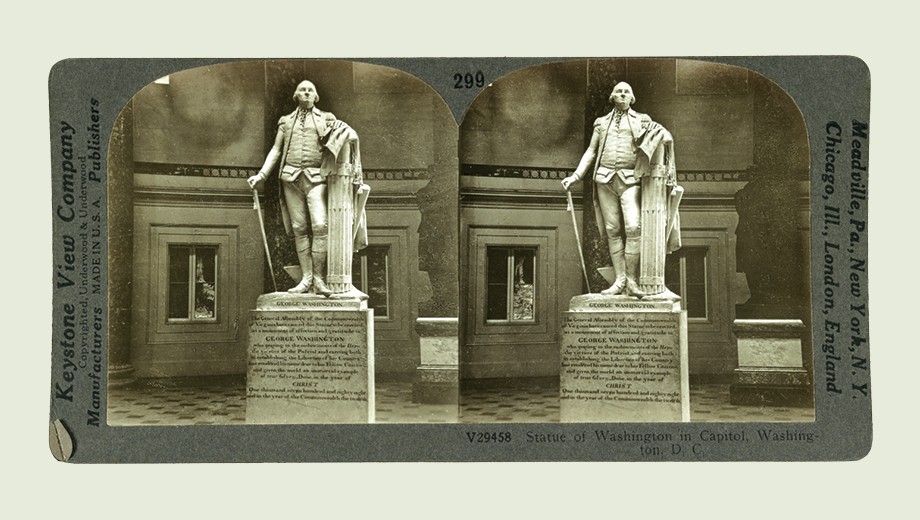 A stereograph card from the early twentieth century shows twin images of a George Washington statue in the United States Capitol.