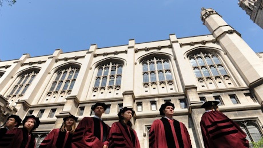 Students in graduation robes in front of the Reynolds Club